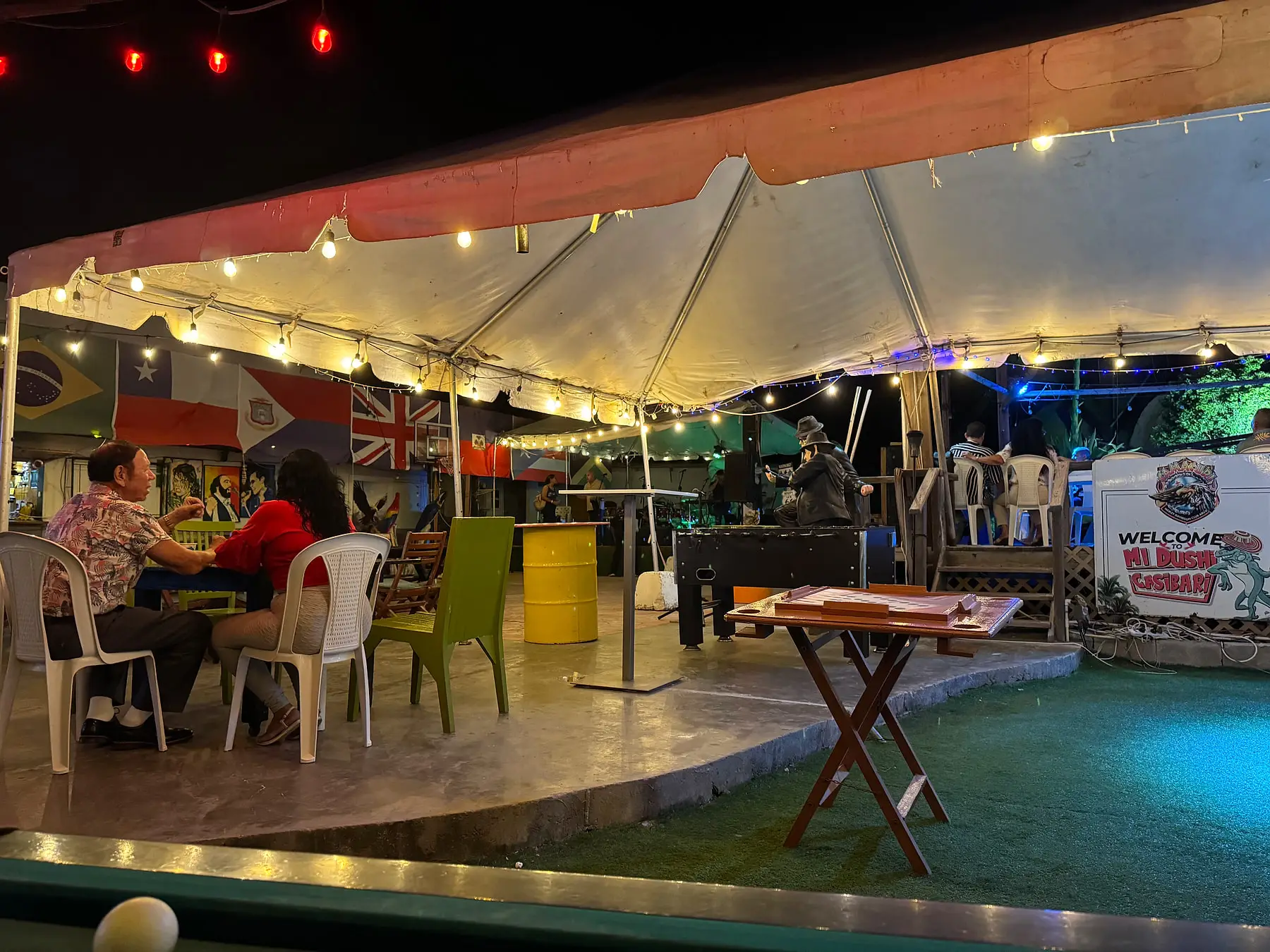Open-air terrace at night with string lights and a stage