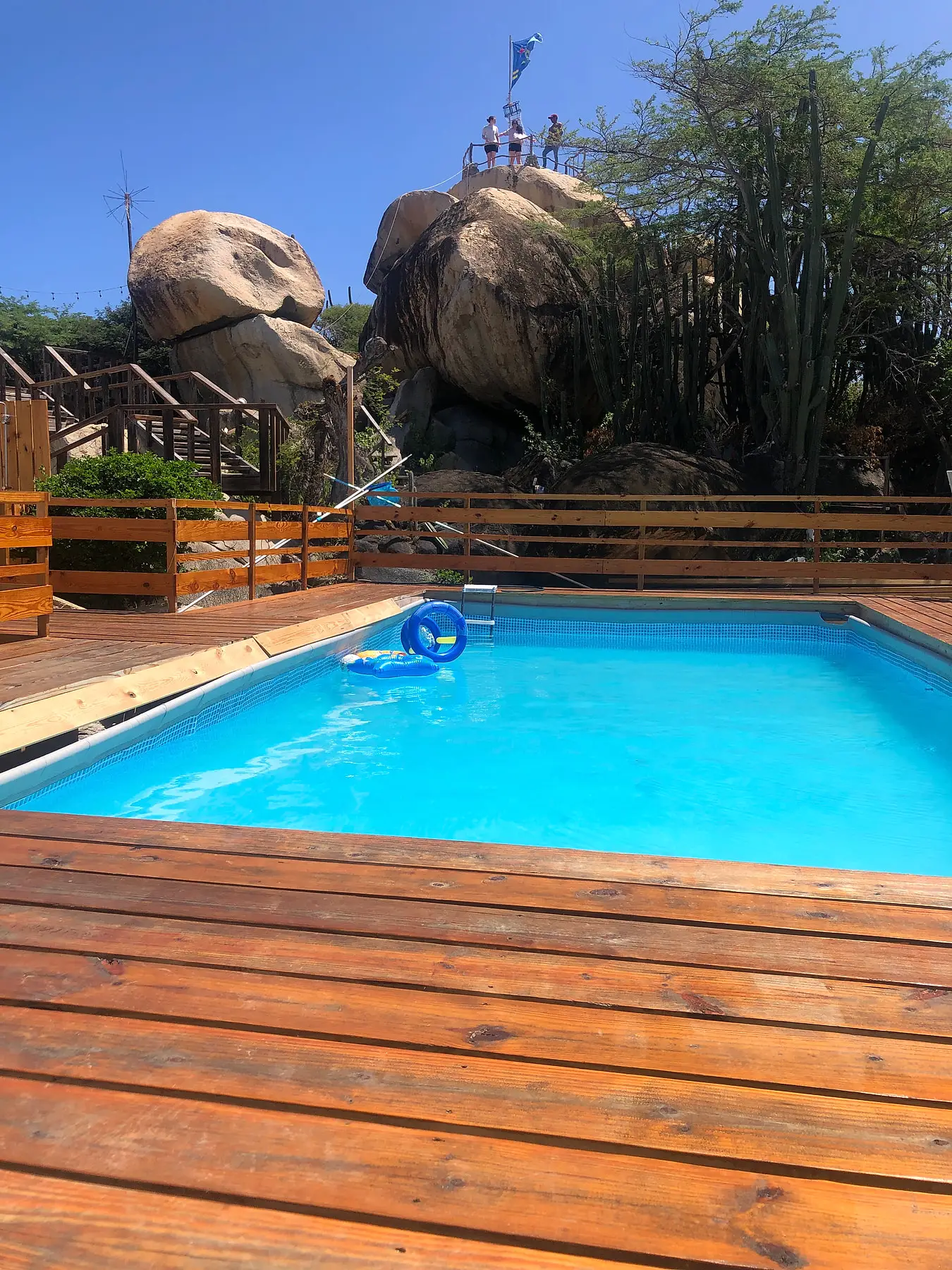 The pool and wooden deck below the Casibari rock formations, with the Aruban flag on top