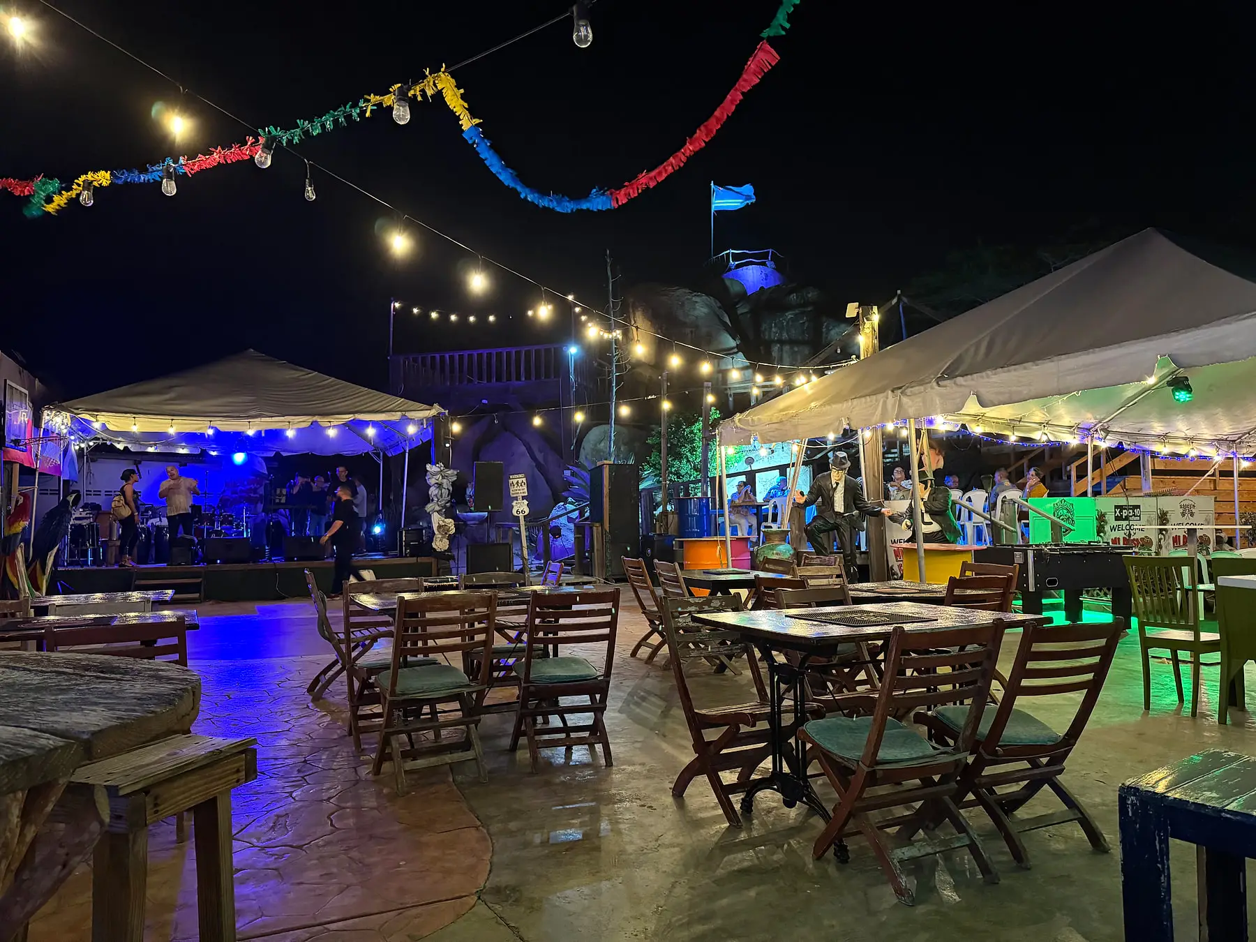 Tables and chairs under string lights at night