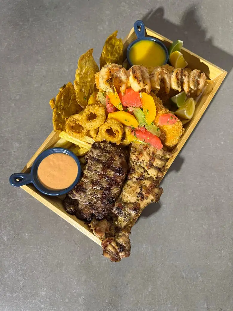 Grilled meat platter with sauces and plantain chips